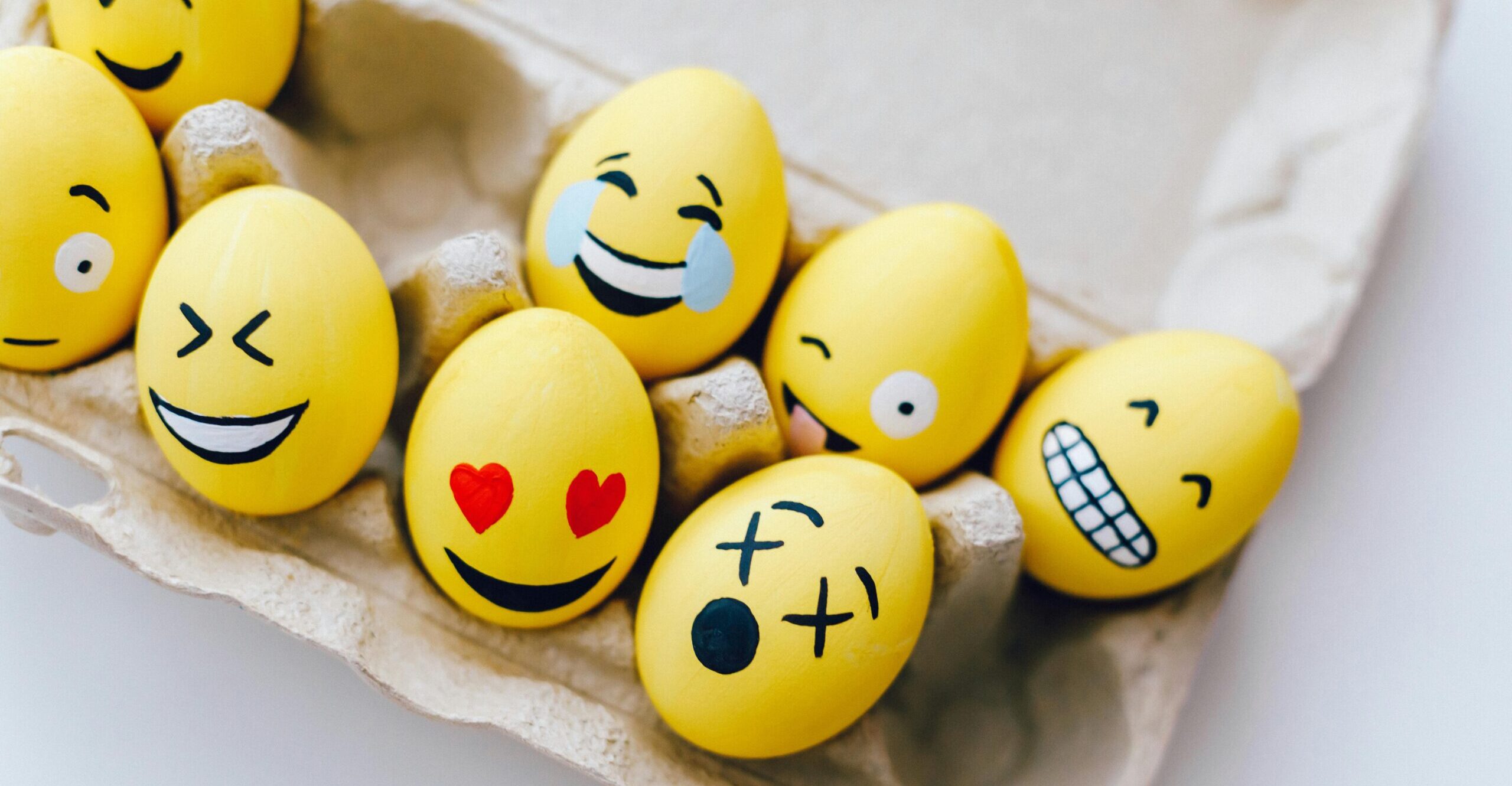 Yellow painted eggs with various facial expressions.