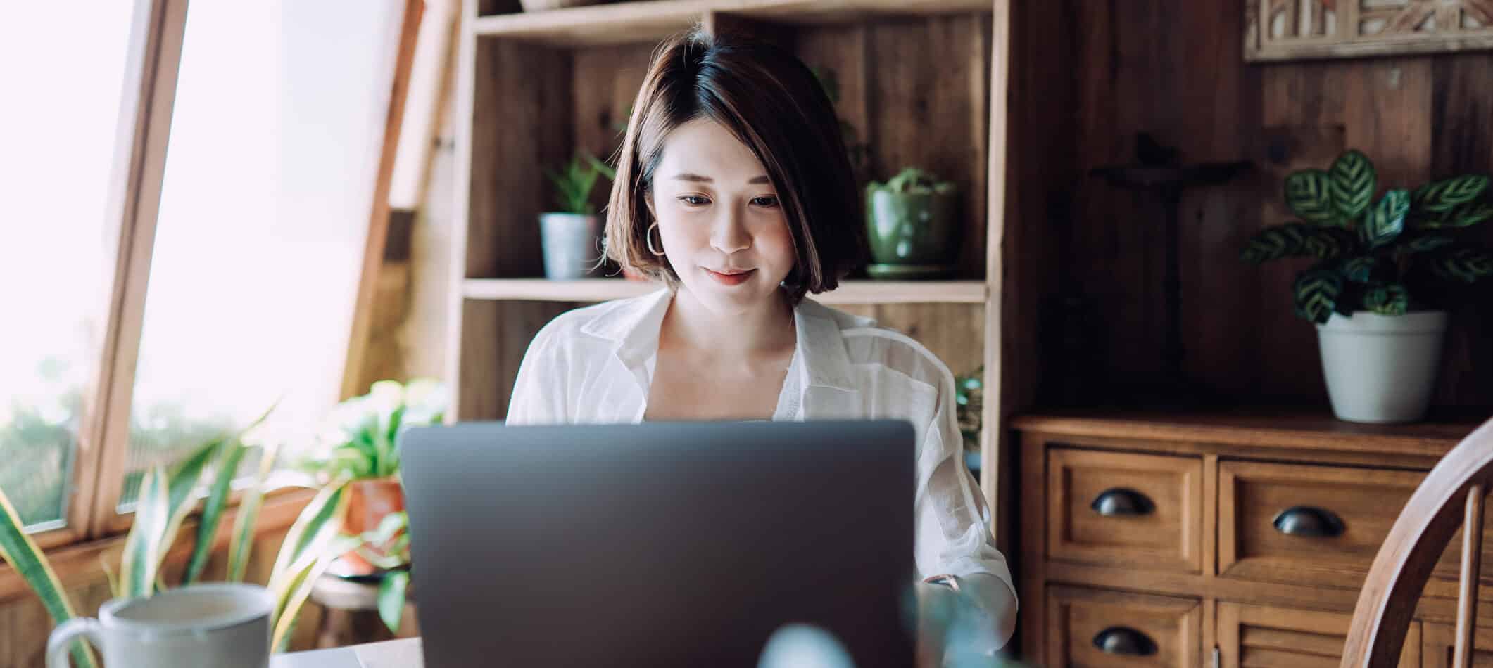 Freelancer working online on a laptop from a home office.
